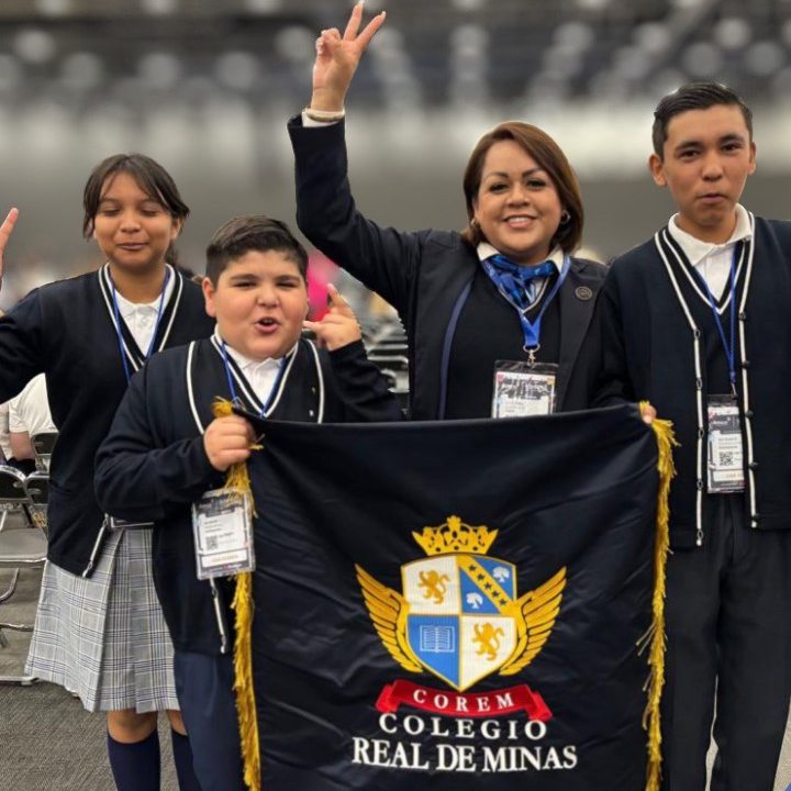 Alumnos y maestras con el estandarte del colegio en el AMCO Summit