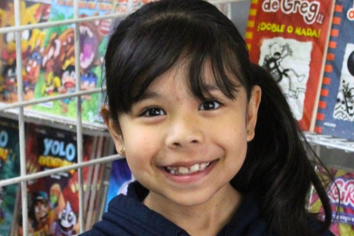 Alumna de Primaria con el libro que escogió en la feria de lectura