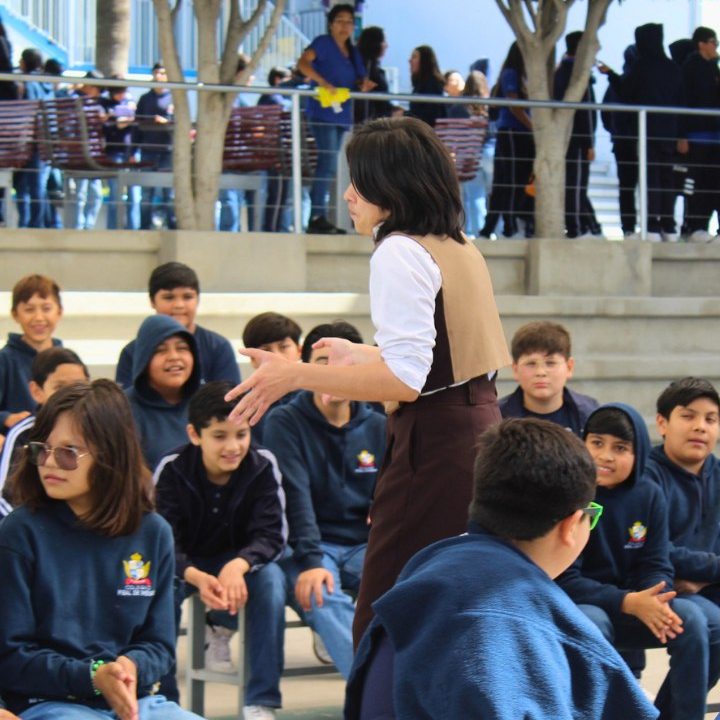 Alumnos escuchan la narración de un cuento en el patio