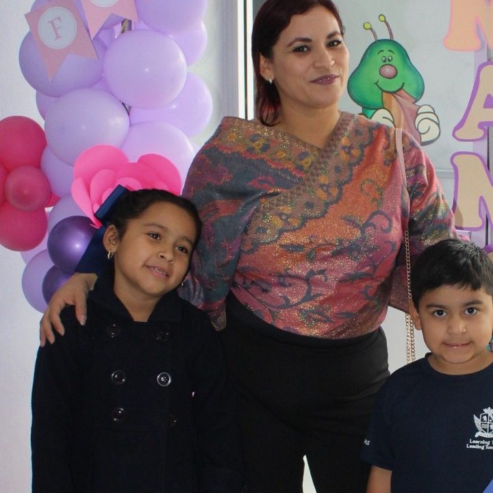 Alumnos de Primaria con sus mamás frente al arco de globos