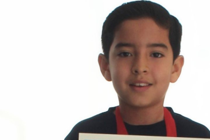 Alumno de Primaria con su reconocimiento al mérito académico