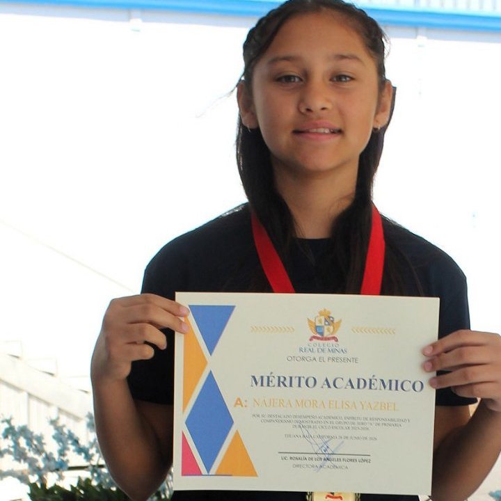 Alumna con su reconocimiento al mérito académico