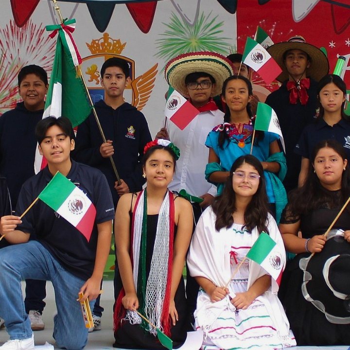 Alumnos de Preparatoria con banderas en la ceremonia cívica