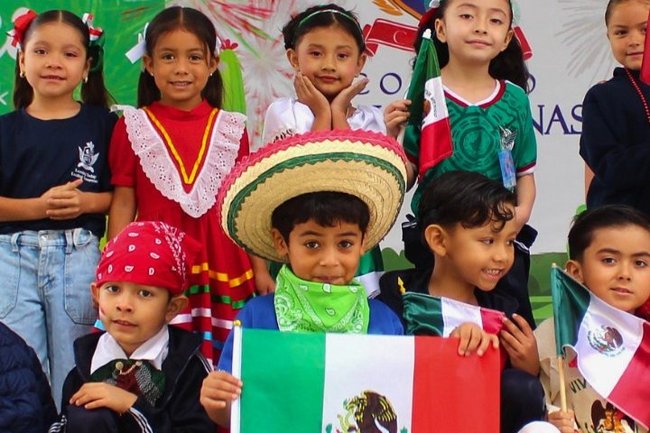 Alumnos de Preescolar con la bandera de México